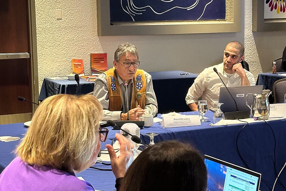 NIEDB Policy Analyst Fadi Cherri listening intently to Darrell Beaulieu President and CEO of Denendeh Investments at a meeting in a conference room.